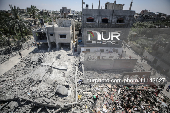 Palestinians are inspecting the damage in a residential building in Deir Al-Balah, in the central Gaza Strip, following Israeli air strikes...