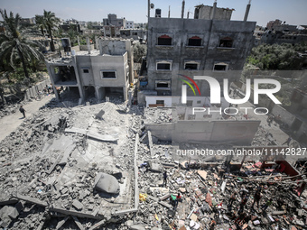 Palestinians are inspecting the damage in a residential building in Deir Al-Balah, in the central Gaza Strip, following Israeli air strikes...