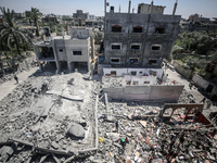 Palestinians are inspecting the damage in a residential building in Deir Al-Balah, in the central Gaza Strip, following Israeli air strikes...