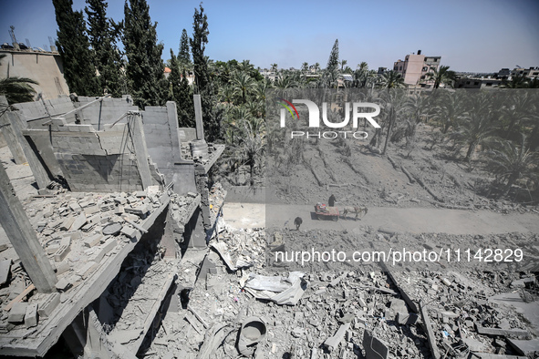 Palestinians are inspecting the damage in a residential building in Deir Al-Balah, in the central Gaza Strip, following Israeli air strikes...