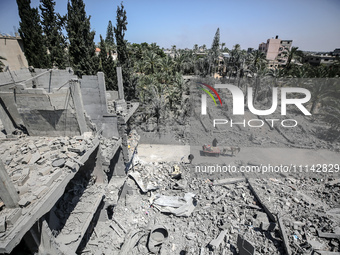 Palestinians are inspecting the damage in a residential building in Deir Al-Balah, in the central Gaza Strip, following Israeli air strikes...