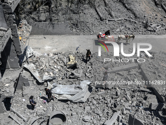 Palestinians are inspecting the damage in a residential building in Deir Al-Balah, in the central Gaza Strip, following Israeli air strikes...