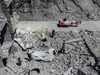 Palestinians are inspecting the damage in a residential building in Deir Al-Balah, in the central Gaza Strip, following Israeli air strikes...