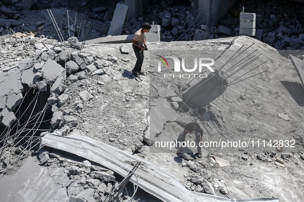 Palestinians are inspecting the damage in a residential building in Deir Al-Balah, in the central Gaza Strip, following Israeli air strikes...