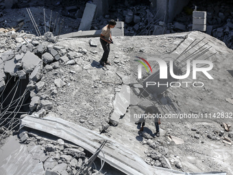 Palestinians are inspecting the damage in a residential building in Deir Al-Balah, in the central Gaza Strip, following Israeli air strikes...