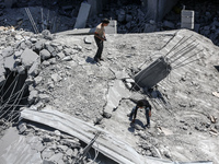 Palestinians are inspecting the damage in a residential building in Deir Al-Balah, in the central Gaza Strip, following Israeli air strikes...