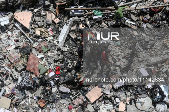 Palestinians are inspecting the damage in a residential building in Deir Al-Balah, in the central Gaza Strip, following Israeli air strikes...