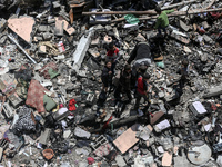 Palestinians are inspecting the damage in a residential building in Deir Al-Balah, in the central Gaza Strip, following Israeli air strikes...