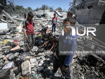 Palestinians are inspecting the damage in a residential building in Deir Al-Balah, in the central Gaza Strip, following Israeli air strikes...