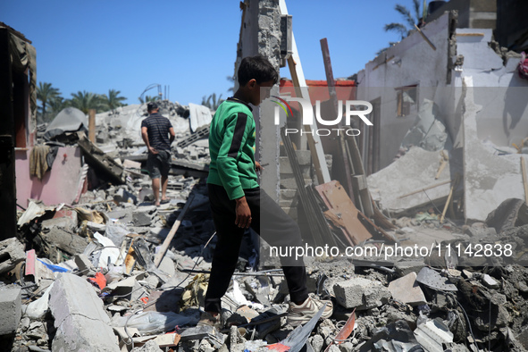 Palestinians are inspecting the damage in a residential building in Deir Al-Balah, in the central Gaza Strip, following Israeli air strikes...