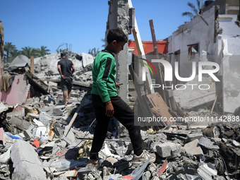 Palestinians are inspecting the damage in a residential building in Deir Al-Balah, in the central Gaza Strip, following Israeli air strikes...