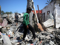 Palestinians are inspecting the damage in a residential building in Deir Al-Balah, in the central Gaza Strip, following Israeli air strikes...