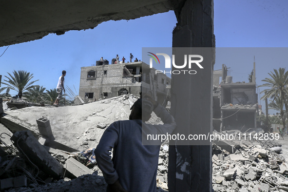 Palestinians are inspecting the damage in a residential building in Deir Al-Balah, in the central Gaza Strip, following Israeli air strikes...