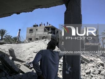 Palestinians are inspecting the damage in a residential building in Deir Al-Balah, in the central Gaza Strip, following Israeli air strikes...