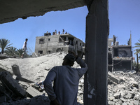 Palestinians are inspecting the damage in a residential building in Deir Al-Balah, in the central Gaza Strip, following Israeli air strikes...