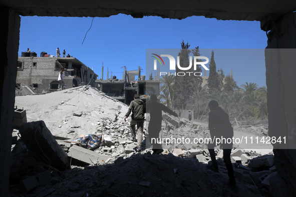 Palestinians are inspecting the damage in a residential building in Deir Al-Balah, in the central Gaza Strip, following Israeli air strikes...