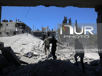 Palestinians are inspecting the damage in a residential building in Deir Al-Balah, in the central Gaza Strip, following Israeli air strikes...