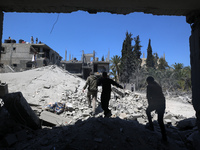 Palestinians are inspecting the damage in a residential building in Deir Al-Balah, in the central Gaza Strip, following Israeli air strikes...