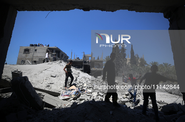 Palestinians are inspecting the damage in a residential building in Deir Al-Balah, in the central Gaza Strip, following Israeli air strikes...