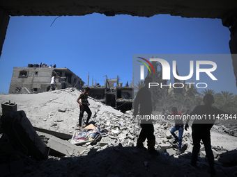 Palestinians are inspecting the damage in a residential building in Deir Al-Balah, in the central Gaza Strip, following Israeli air strikes...