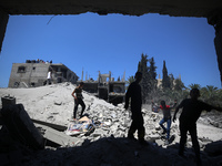 Palestinians are inspecting the damage in a residential building in Deir Al-Balah, in the central Gaza Strip, following Israeli air strikes...