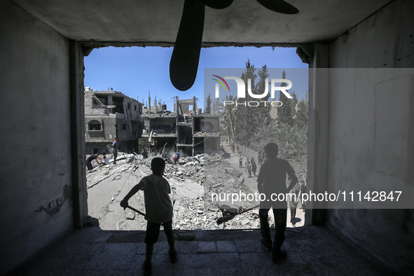 Palestinians are inspecting the damage in a residential building in Deir Al-Balah, in the central Gaza Strip, following Israeli air strikes...