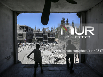 Palestinians are inspecting the damage in a residential building in Deir Al-Balah, in the central Gaza Strip, following Israeli air strikes...