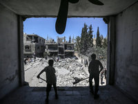 Palestinians are inspecting the damage in a residential building in Deir Al-Balah, in the central Gaza Strip, following Israeli air strikes...