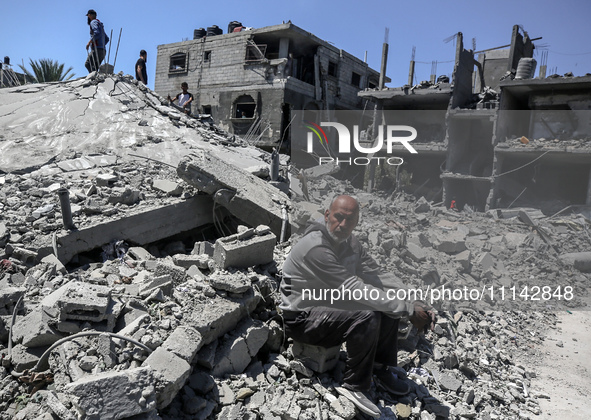 Palestinians are inspecting the damage in a residential building in Deir Al-Balah, in the central Gaza Strip, following Israeli air strikes...