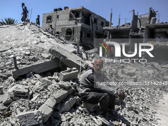 Palestinians are inspecting the damage in a residential building in Deir Al-Balah, in the central Gaza Strip, following Israeli air strikes...