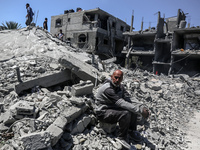 Palestinians are inspecting the damage in a residential building in Deir Al-Balah, in the central Gaza Strip, following Israeli air strikes...