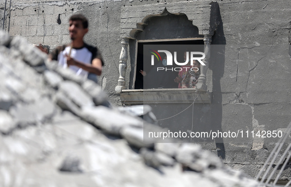 Palestinians are inspecting the damage in a residential building in Deir Al-Balah, in the central Gaza Strip, following Israeli air strikes...