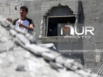 Palestinians are inspecting the damage in a residential building in Deir Al-Balah, in the central Gaza Strip, following Israeli air strikes...