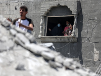 Palestinians are inspecting the damage in a residential building in Deir Al-Balah, in the central Gaza Strip, following Israeli air strikes...