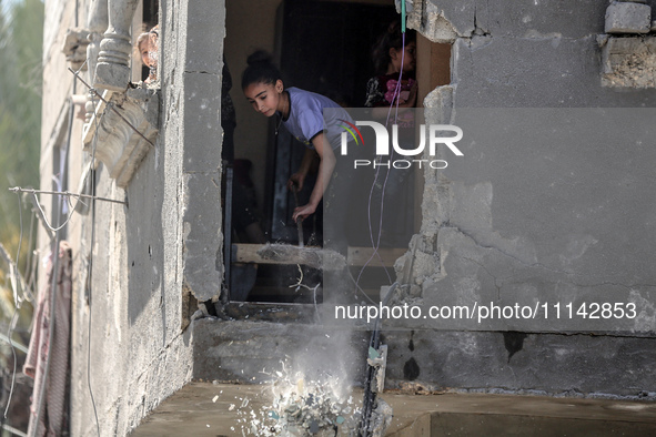 Palestinians are inspecting the damage in a residential building in Deir Al-Balah, in the central Gaza Strip, following Israeli air strikes...