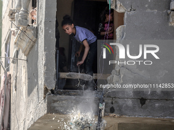 Palestinians are inspecting the damage in a residential building in Deir Al-Balah, in the central Gaza Strip, following Israeli air strikes...