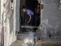 Palestinians are inspecting the damage in a residential building in Deir Al-Balah, in the central Gaza Strip, following Israeli air strikes...