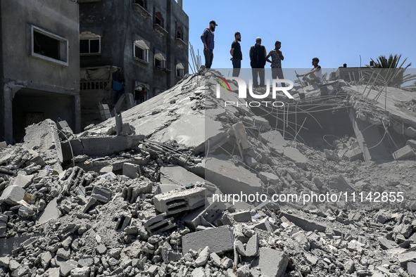 Palestinians are inspecting the damage in a residential building in Deir Al-Balah, in the central Gaza Strip, following Israeli air strikes...