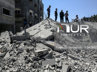 Palestinians are inspecting the damage in a residential building in Deir Al-Balah, in the central Gaza Strip, following Israeli air strikes...