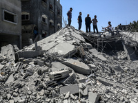 Palestinians are inspecting the damage in a residential building in Deir Al-Balah, in the central Gaza Strip, following Israeli air strikes...