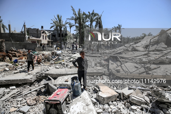 Palestinians are inspecting the damage in the rubble of Abu Bakr Al-Siddiq Mosque, which was leveled by Israeli bombardment in Deir Al-Balah...