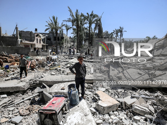 Palestinians are inspecting the damage in the rubble of Abu Bakr Al-Siddiq Mosque, which was leveled by Israeli bombardment in Deir Al-Balah...