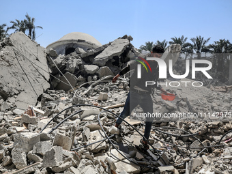 A Palestinian man is walking near the Abu Bakr Al-Siddiq Mosque, which was leveled by Israeli bombardment in Deir Al-Balah, in the central G...