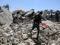 A Palestinian man is walking near the Abu Bakr Al-Siddiq Mosque, which was leveled by Israeli bombardment in Deir Al-Balah, in the central G...