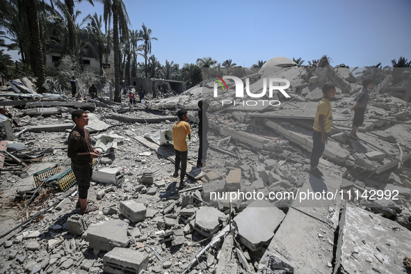 Palestinians are inspecting the damage in the rubble of Abu Bakr Al-Siddiq Mosque, which was leveled by Israeli bombardment in Deir Al-Balah...