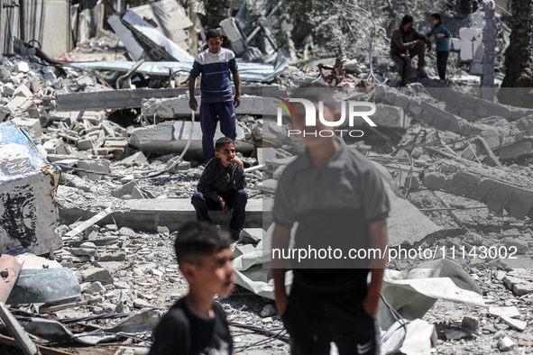 Palestinians are inspecting the damage in the rubble of Abu Bakr Al-Siddiq Mosque, which was leveled by Israeli bombardment in Deir Al-Balah...