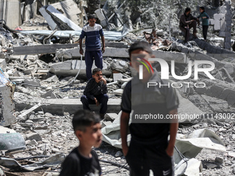 Palestinians are inspecting the damage in the rubble of Abu Bakr Al-Siddiq Mosque, which was leveled by Israeli bombardment in Deir Al-Balah...