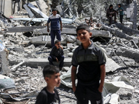 Palestinians are inspecting the damage in the rubble of Abu Bakr Al-Siddiq Mosque, which was leveled by Israeli bombardment in Deir Al-Balah...