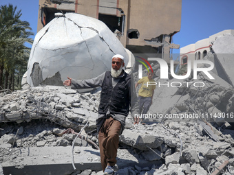 A Palestinian man is reacting near the Abu Bakr Al-Siddiq Mosque, which has been leveled by Israeli bombardment in Deir Al-Balah, in the cen...