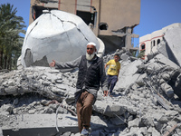 A Palestinian man is reacting near the Abu Bakr Al-Siddiq Mosque, which has been leveled by Israeli bombardment in Deir Al-Balah, in the cen...